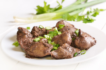 Cooked chicken liver with green onion on white plateの写真素材