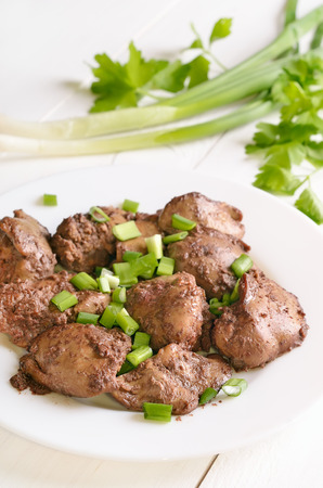 Chicken liver with green onion on white plateの写真素材