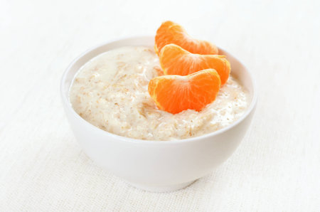 Oatmeal porridge with slices of tangerinesの写真素材