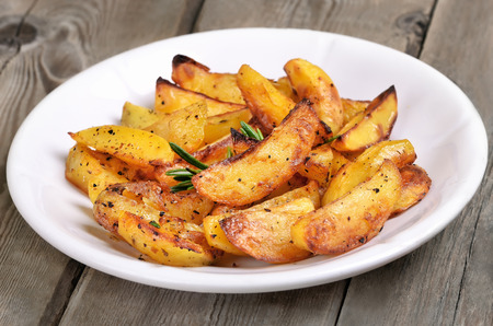 Potato wedges on white plate, fast food, close up viewの写真素材