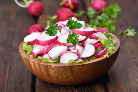 Spring salad with fresh radish on wooden table, close up viewの写真素材