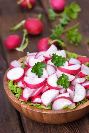 Fresh radish salad in bowl on wooden table, close up viewの写真素材