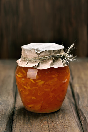 Orange homemade jam marmelade in glass jar on wooden tableの写真素材