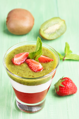 Kiwi strawberry layered dessert with creamy yogurt in glassの写真素材