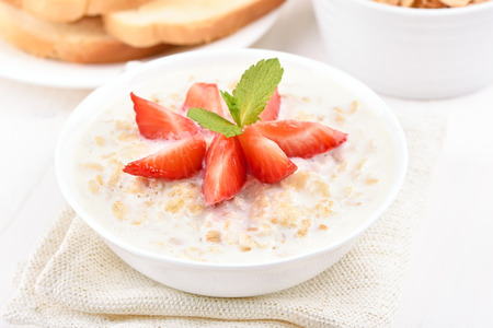 Breakfast oatmeal porridge with strawberry slicesの写真素材