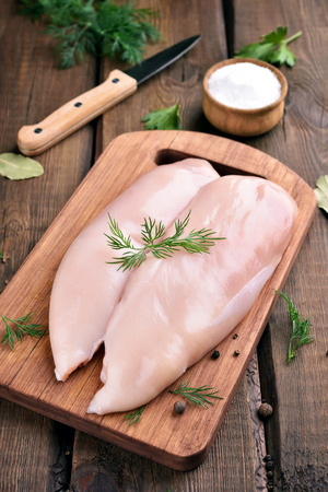 Raw chicken meat on cutting boardの写真素材