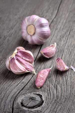 Vegetable cloves of garlic on wooden background, focus on garlic in frontの写真素材