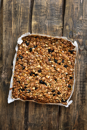 Granola on baking paper over wooden table, top viewの写真素材