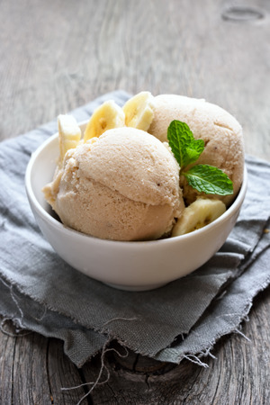 Banana ice cream in bowl on country tableの写真素材