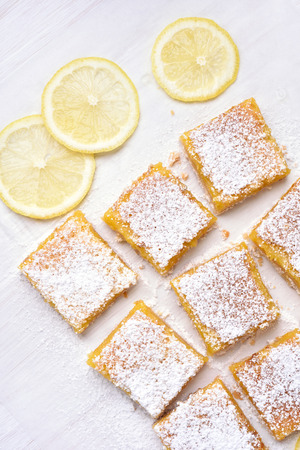 Lemon bars and fresh slices over baking paper, top viewの写真素材