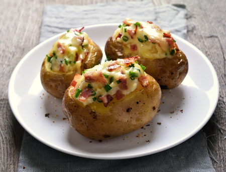 Stuffed potato with bacon, cheese and green onionの写真素材