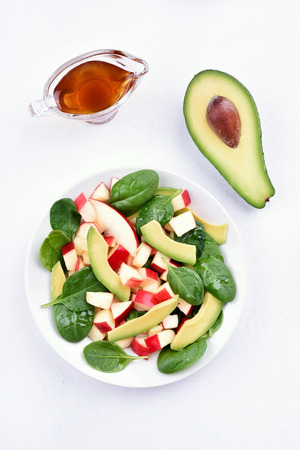 Diet healthy fruit salad with apples, avocado, spinach on light background, top viewの写真素材