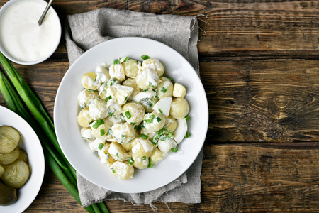 Dinner with potato salad on wooden background with copy space, top viewの写真素材