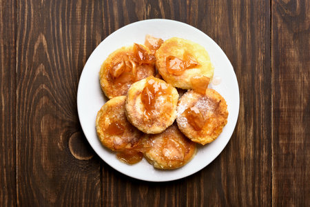 Curd cheese pancakes with caramelized apple slices on wooden table. Top view, flat lay. の写真素材