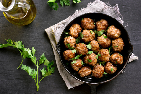 Meatballs in frying pan on black stone background. Top view, flat layの写真素材