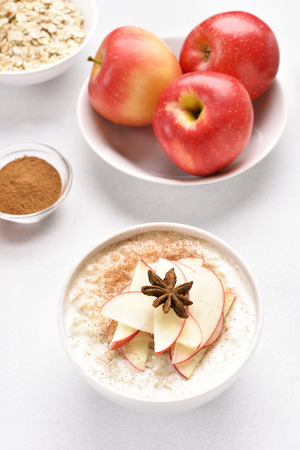 Oats porridge with red apple slices and cinnamon. Healthy diet breakfast concept. Top view
の写真素材