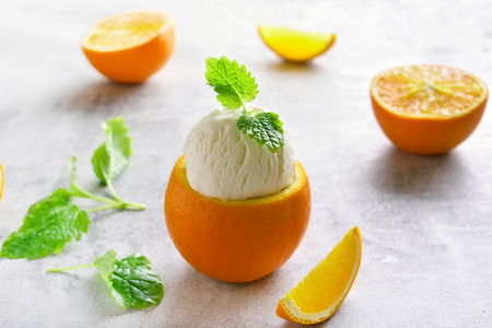 Ice cream in orange on stone background. Cold summer dessertの写真素材