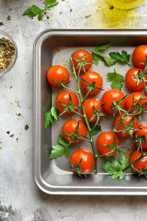 Roasted cherry tomatoes in baking tray on stone table. Top view, flat layの写真素材