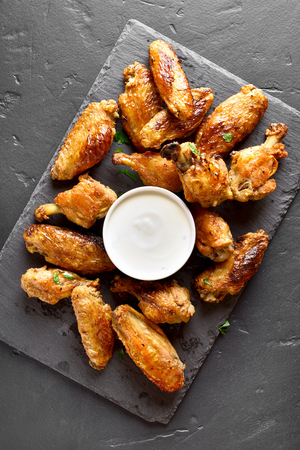 Grilled chicken wings with sauce on black stone background. Top view, flat layの写真素材