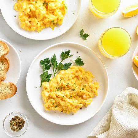 Scrambled eggs on plate over white stone background. Top view, flat layの写真素材