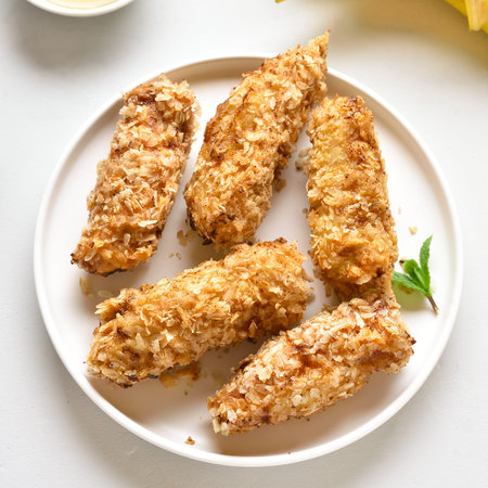 Tasty dessert from pan fried bananas in asian style. Deep fried bananas on plate over white stone...