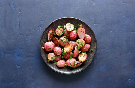 Roasted radish on plate over blue stone background with free space for text. Top view, flat layの写真素材