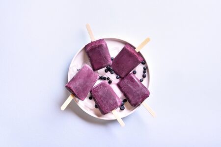 Blueberry popsicles on blue stone background with free space. Cold summer dessert. Top view, flat layの写真素材