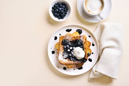 French toasts with blueberry sauce on stone background with free space. Top view, flat layの写真素材