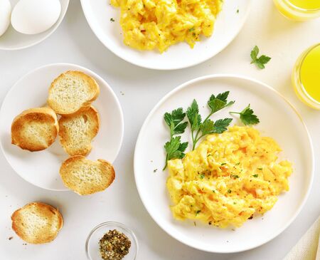 Scrambled eggs on plate over white stone background. Top view, flat layの写真素材