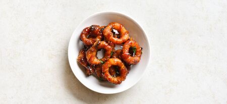 Bacon wrapped onion rings in bowl over light stone background with free space.の写真素材