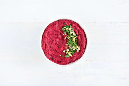 Homemade beet hummus in bowl over light wooden background with free text space. Top view, flat layの写真素材