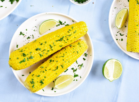Close up of boiled corn cobs on plate. Top view, flat lay