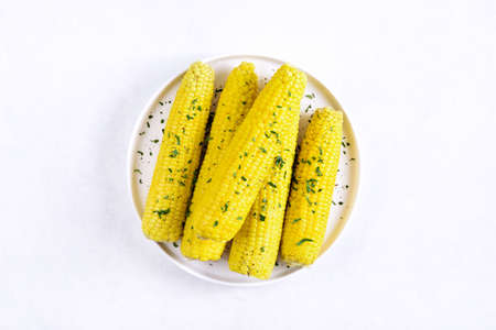 Boiled corn cobs on plate over white stone background with free text space. Top view, flat lay, close upの写真素材