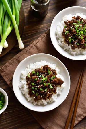 Korean ground beef and rice bowls on wooden background. Top view, flat layの写真素材