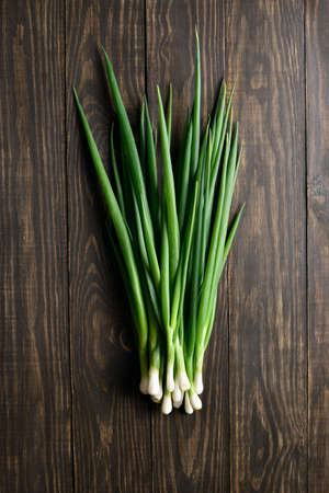 Fresh green onion on wooden background. Top view, flat layの写真素材