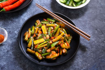 Korean style cucumber kimchi on plate over blue stone background. Close up viewの写真素材