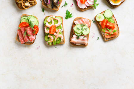 Assortment open sandwiches on light stone background with copy space. Top view, flat lay.の写真素材