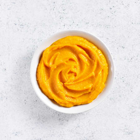 Pumpkin puree in bowl over light stone background with free text space. Healthy diet food concept. Top view, flat layの写真素材