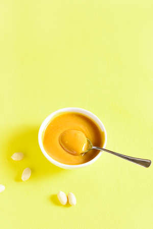 Peanut sauce in bowl over yellow background with free text space.の写真素材