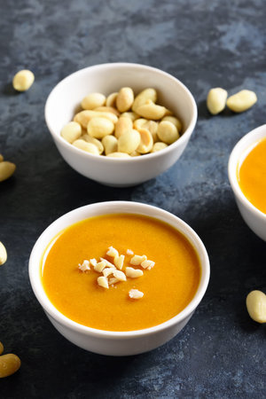 Peanut sauce in bowl over blue stone background. Close up view