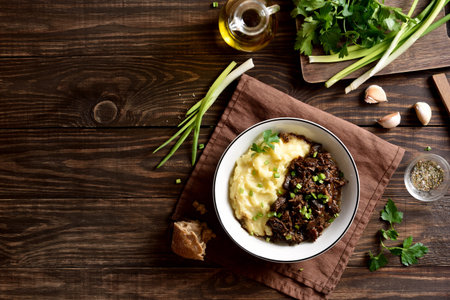 Slow cooked beef with mashed potatoes on wooden background with free text space. Top view, flat lay