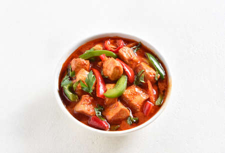 Close up view of thai style red chicken curry with vegetables in bowl over light background with free text space.の写真素材