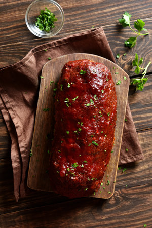 Meatloaf with glaze on board over wooden background. Top view, flat lay, close upの写真素材