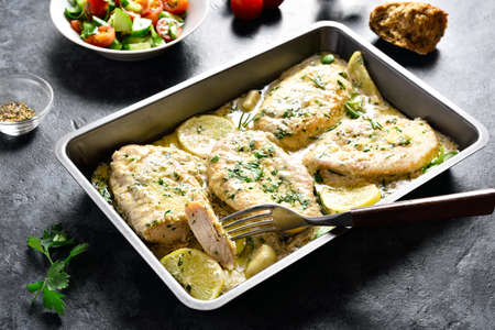 Chicken breast in creamy garlic sauce in baking dish on stone background. Healthy diet food.の写真素材