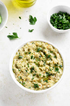 Baba ganoush (roasted eggplant dip) in bowl over light stone background.の写真素材