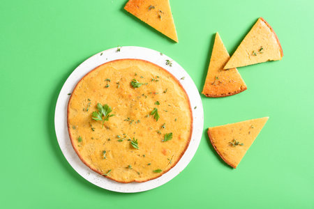 Socca gluten-free chickpea flatbread on cutting board over green background. Top view, flat layの写真素材