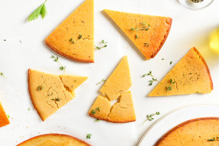Slices of socca gluten-free chickpea flatbread over white background. Top view, flat lay