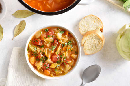 Cabbage soup in bowl over white stone background. top view, flat layの写真素材