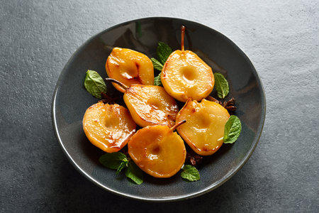 Poached pears on plate over dark stone background with free text space. close up viewの写真素材