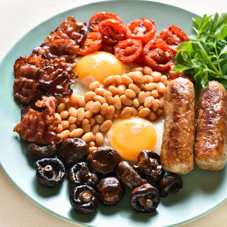 Full english breakfast with fried egg, bacon, sausage, beans and mushrooms. close up viewの写真素材